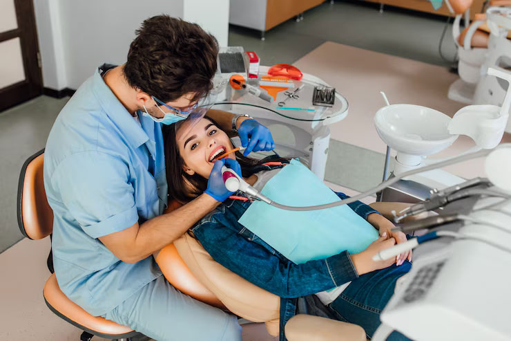 a dentist is checking a lady's teeth